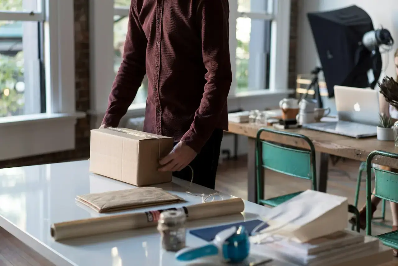 Small business owner sealing a shipping box, representing Amazon seller order fulfillment