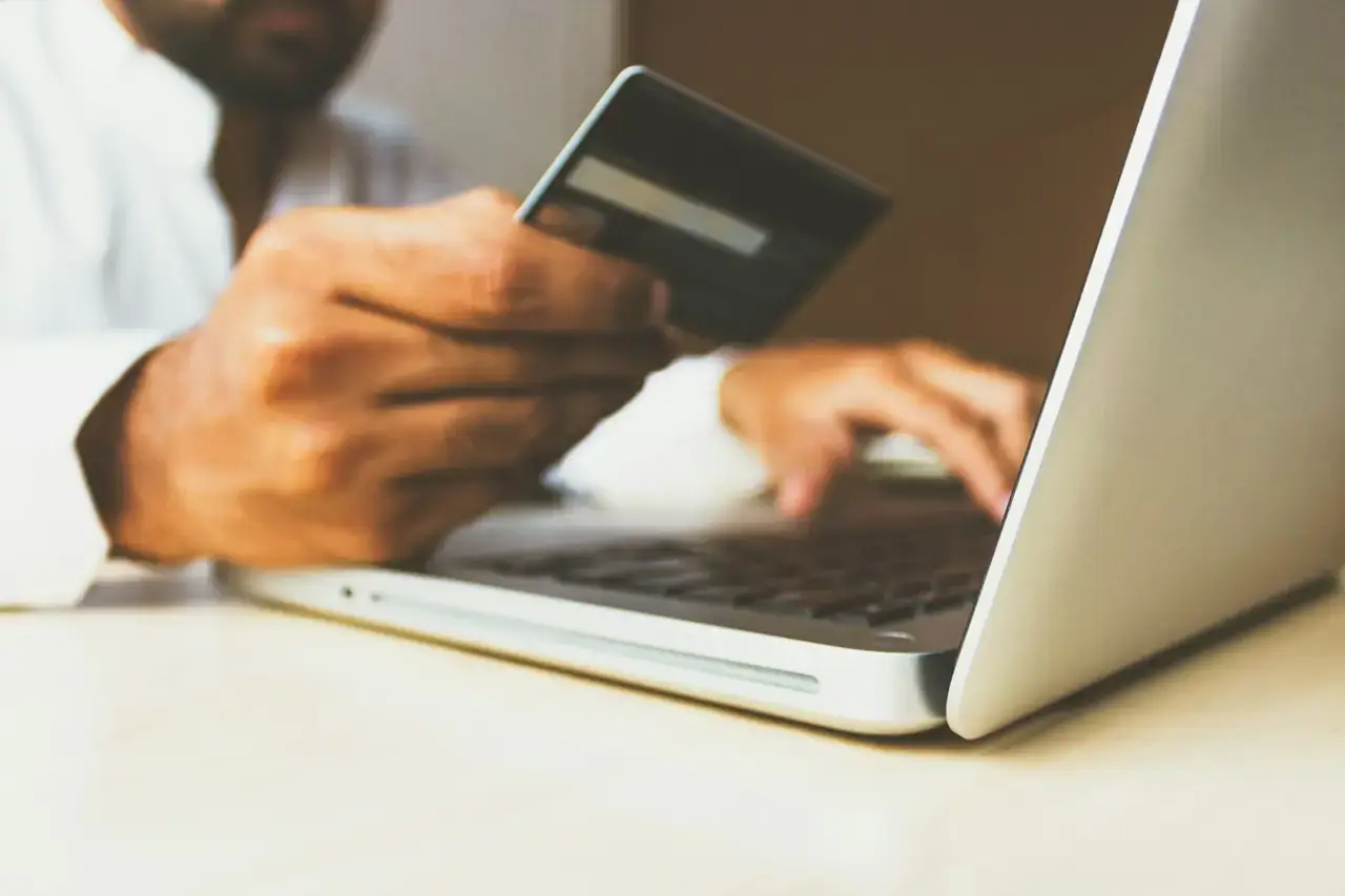 Person completing an online checkout with a card on a laptop, representing Buy Box price competition