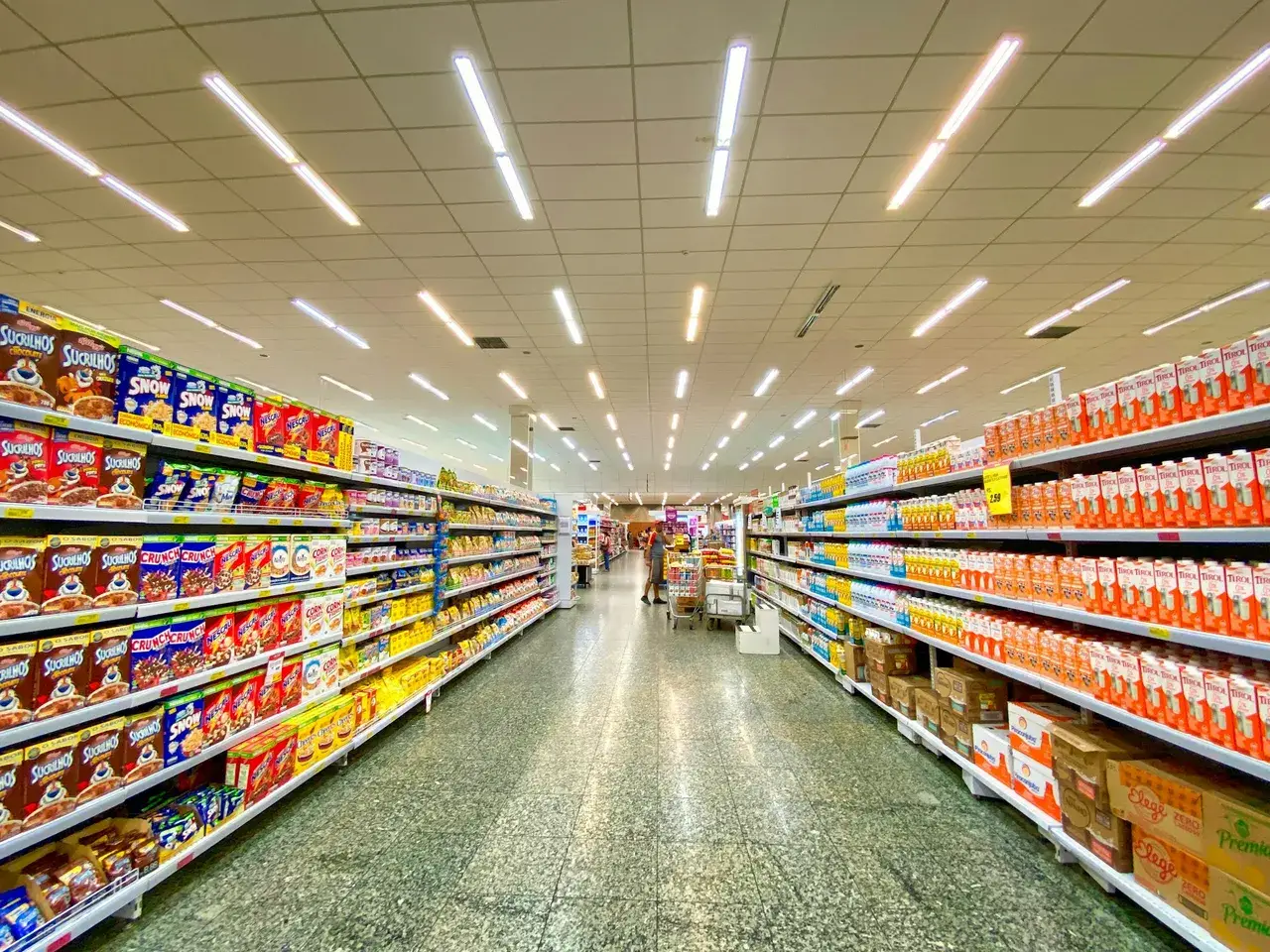 Grocery store aisle with fully stocked shelves, representing dark-store inventory and assortment
